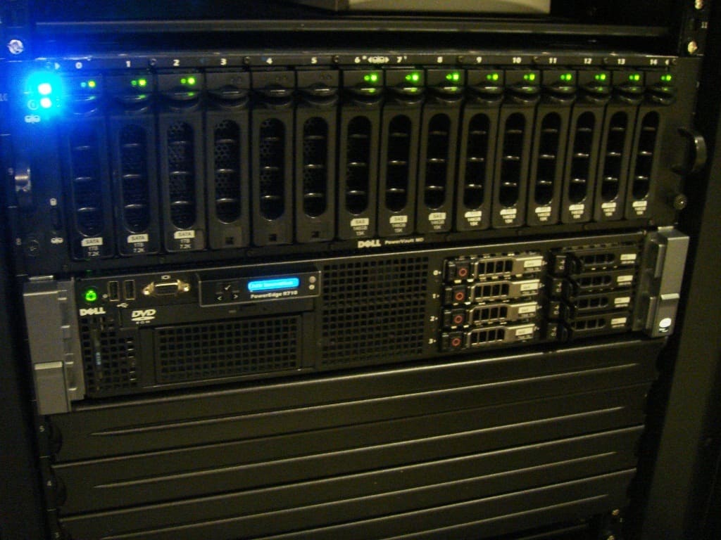 Cabina de discos Dell PowerVault MD con catorce bahías con LEDs verdes sobre un servidor PowerEdge R710.