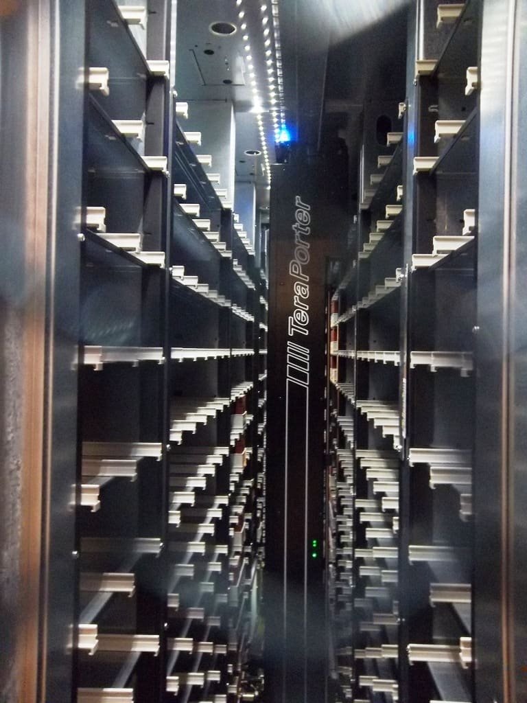 Interior de biblioteca de cintas con el robot TeraPorter y filas de estantes de ranuras vacías en perspectiva