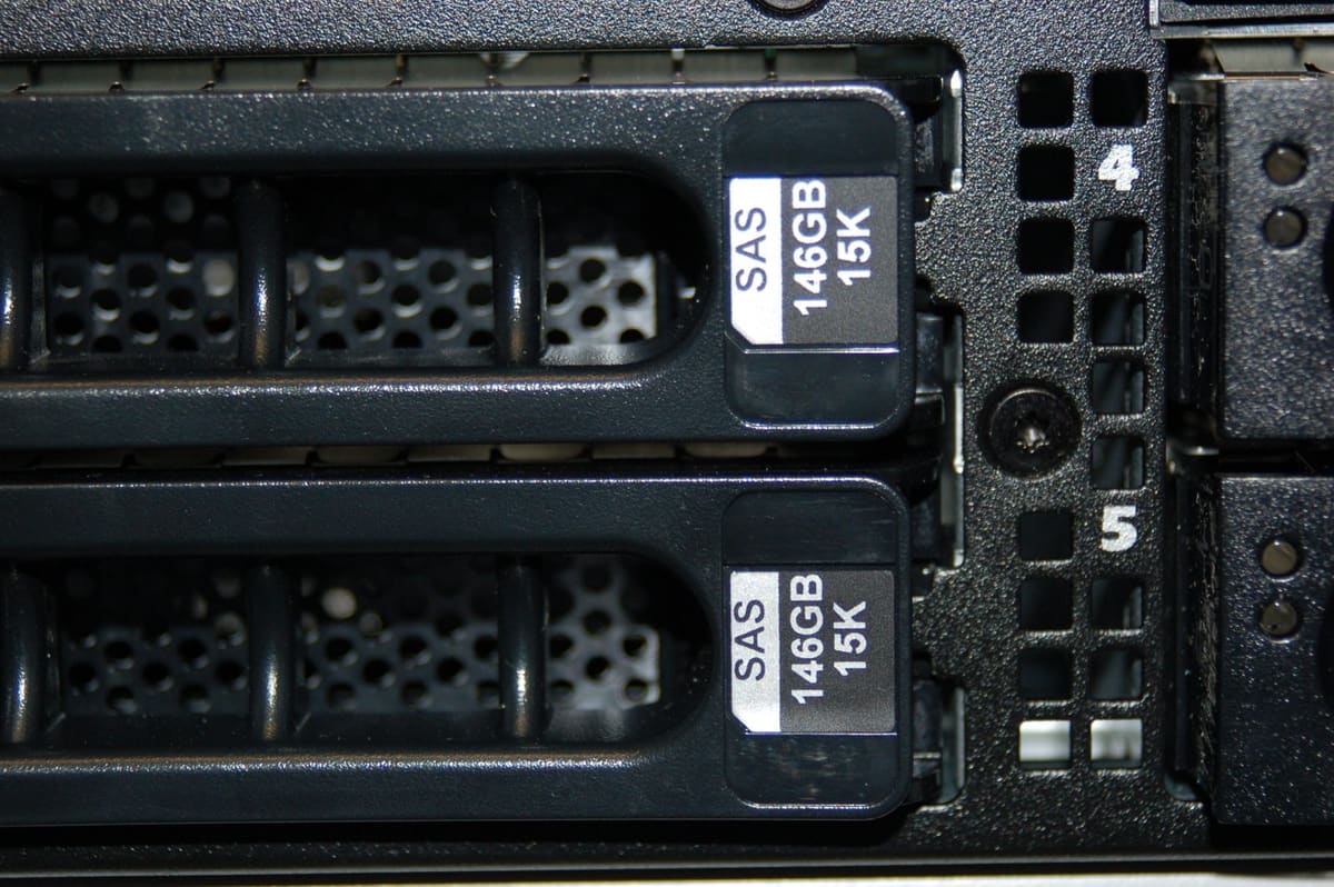 Primer plano de dos carros de disco etiquetados SAS 146GB 15K en las bahías numeradas 4 y 5
