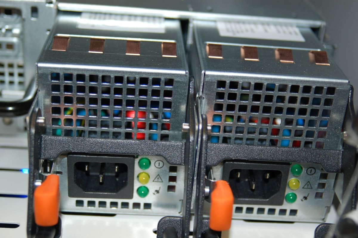 Dos fuentes de alimentacion redundantes vistas por detras, con conector C14, palanca naranja y LEDs de estado