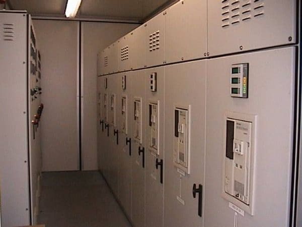 Cuadros de distribución eléctrica de baja tensión con interruptores en fila dentro de una sala técnica